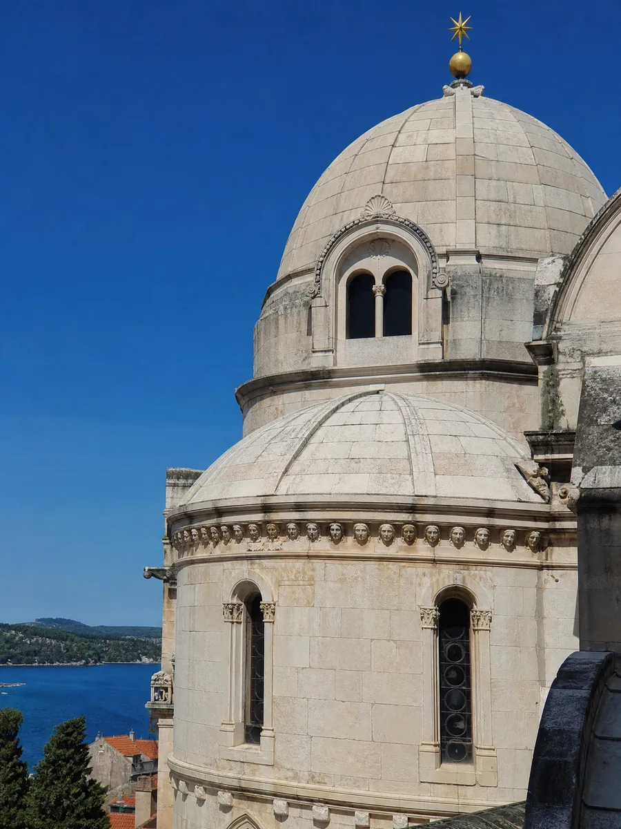 Die Steinkuppel und die Apsis der Kathedrale des heiligen Jakob in Šibenik vor blauem Himmel